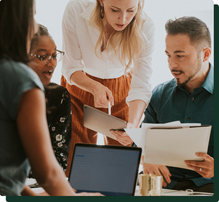 A group of people meeting discussing paperwork representing the collaboration between cfs and it's clients | cfs insight services